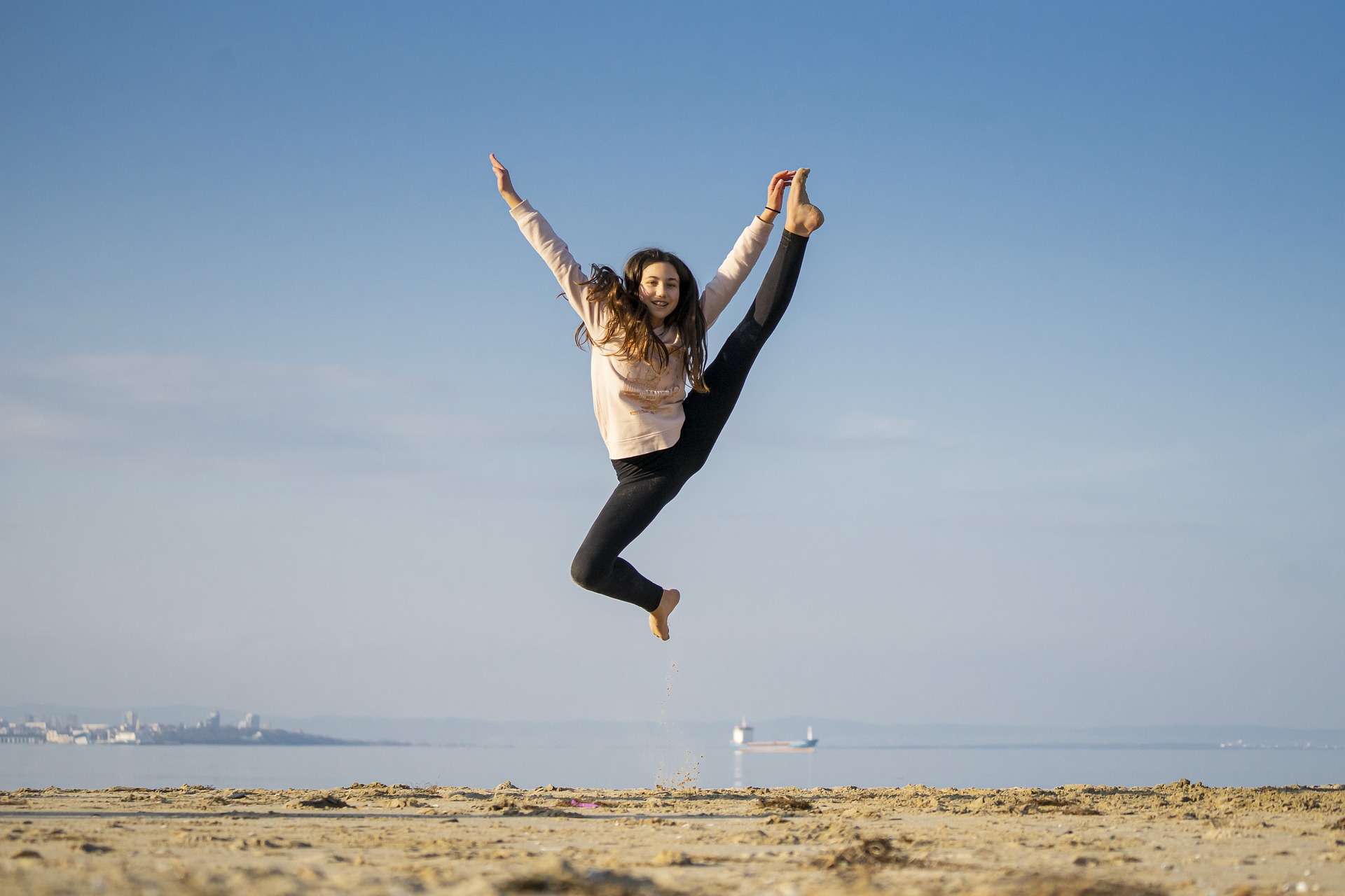 Girl jumping and smiling on the beach